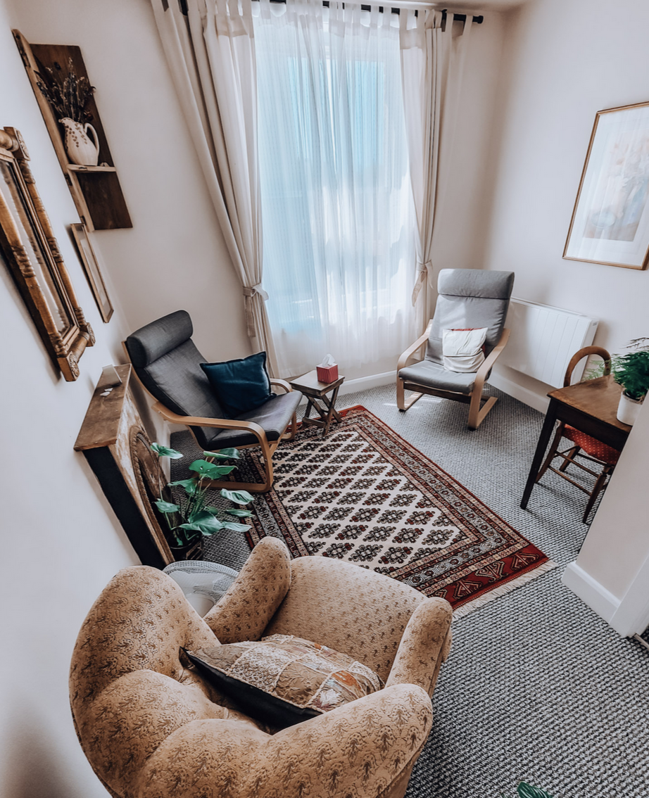 Two armchairs facing each other in a calm London consulting room used for couples therapy